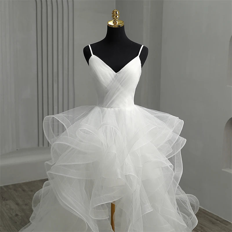 Close-up of the V-neckline and spaghetti strap design on the white high-low wedding dress.