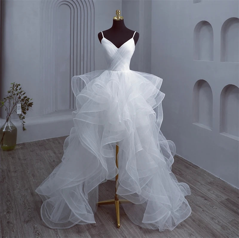 Mannequin display of the high-low bridal gown, showcasing the transition between the short front and long back skirt layers.
