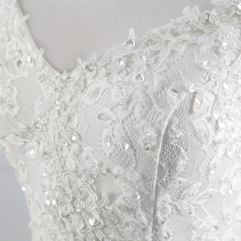 Close-up of the intricate floral lace embroidery and sequin embellishments on the bodice of an off-shoulder wedding dress.