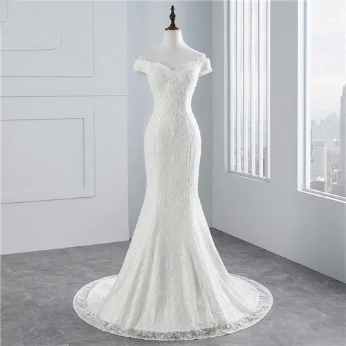 A mannequin showcasing the full silhouette of an off-shoulder mermaid wedding dress with a long lace-trimmed train.