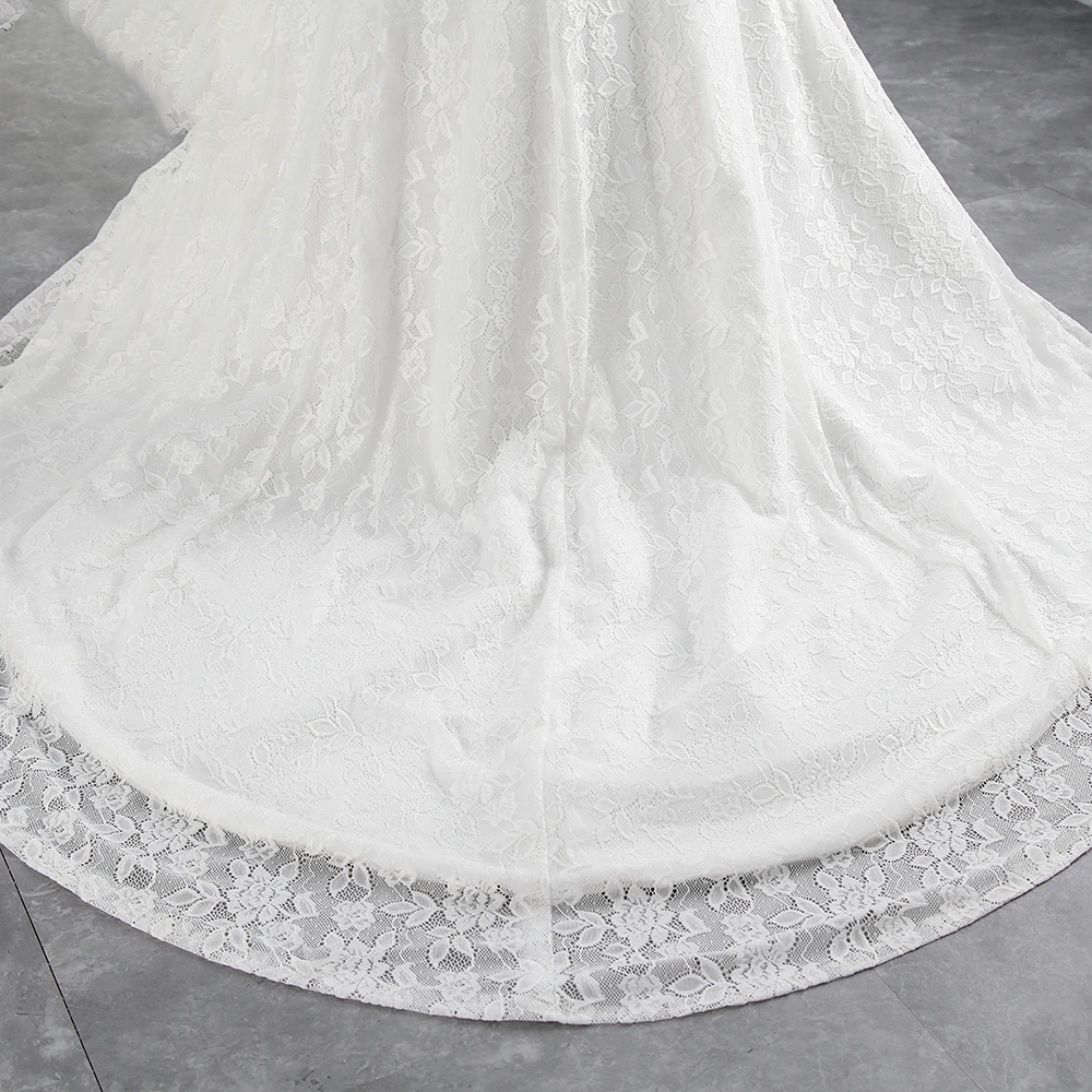 A rear view of an off-shoulder mermaid wedding dress on a mannequin, highlighting the lace-up corset detail and chapel train.