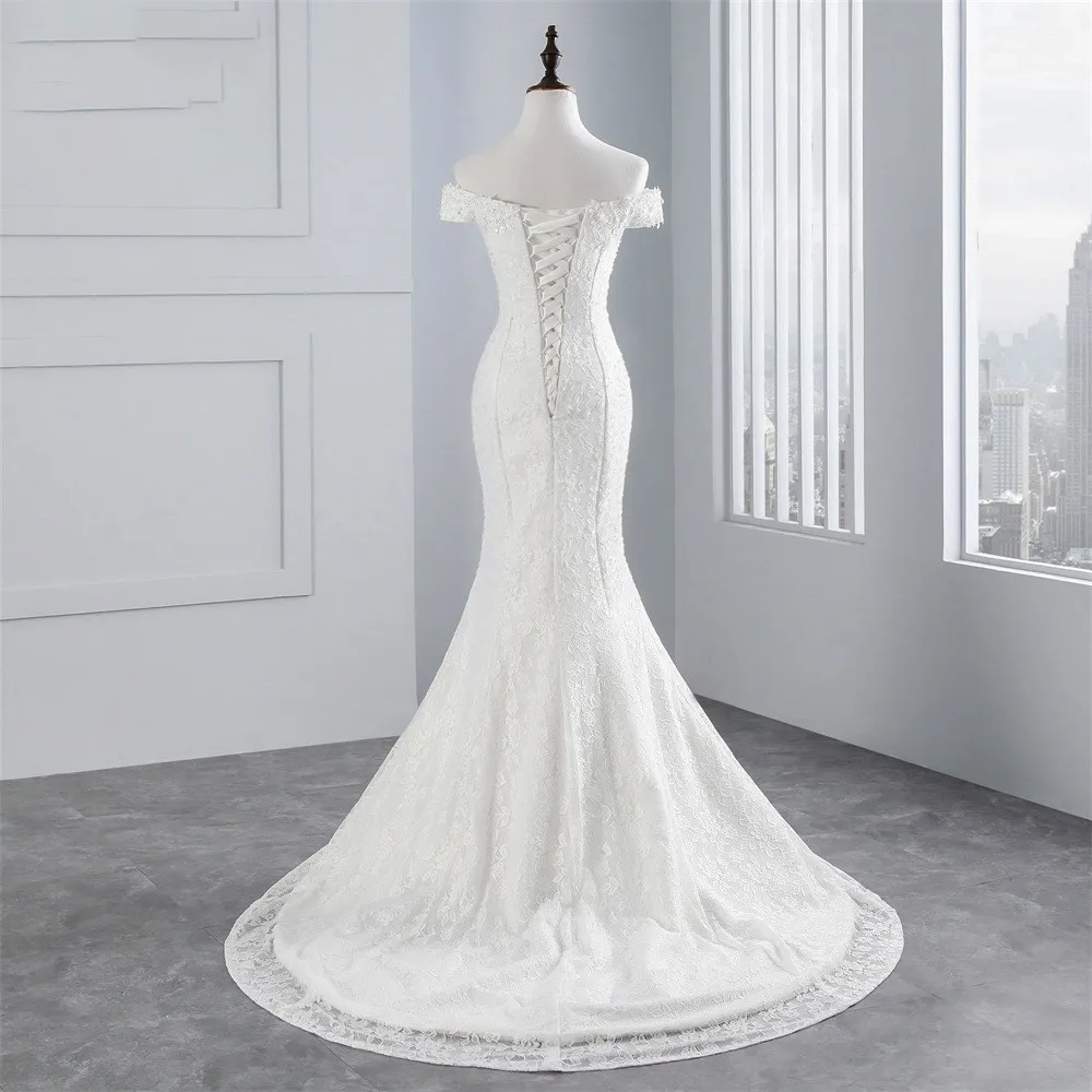 A close-up of the lace-up corset back detail and delicate lace overlay on a mermaid bridal gown.