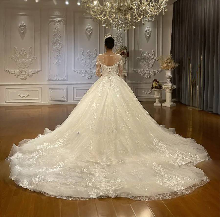 Rear view of an A-line wedding dress showcasing a heart-shaped keyhole back and a dramatic cathedral-length lace train.