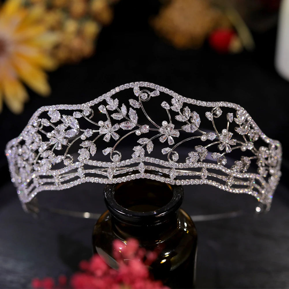 Direct front view of a luxury Europe bridal wedding crown diadem with marquise crystal leaves and tiny pearl accents on a dark base.