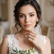 Portrait of a bride wearing the Newshe 2-piece vintage wedding ring bridal set featuring a large princess-cut center stone.