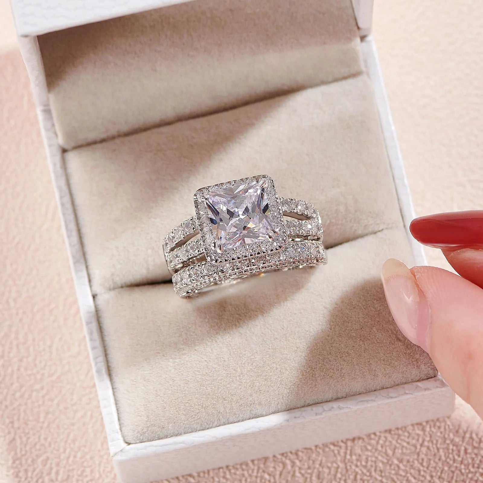 Front view of the 2-piece princess-cut cubic zirconia bridal set nested inside a textured white presentation jewelry box.