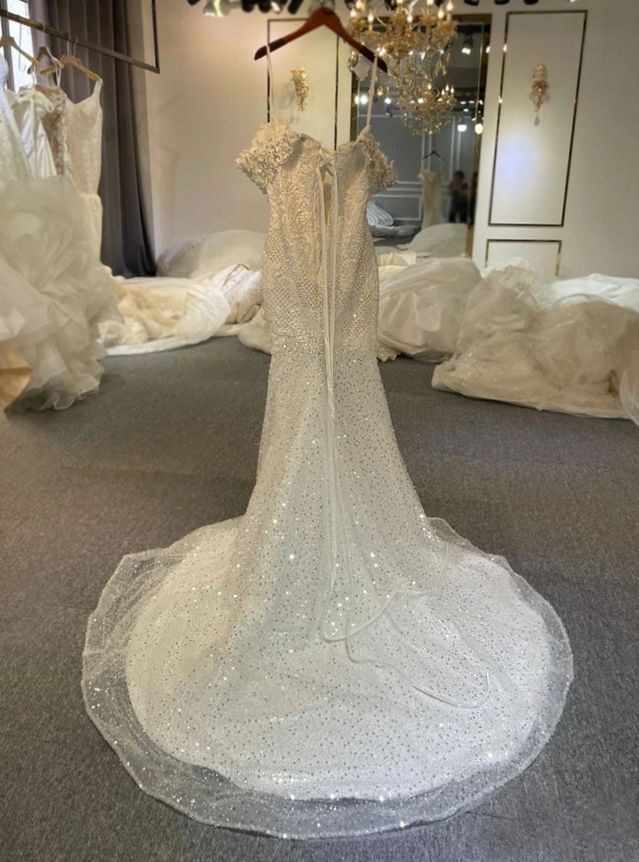 Rear view of the crystal-embellished lace mermaid wedding dress on a hanger, showcasing the elegant lace-up corset back and the sparkling court-length train.