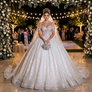 Full-length front view of an elegant model wearing an off-shoulder princess wedding dress with intricate crystal beaded details and a voluminous tulle ball gown skirt.