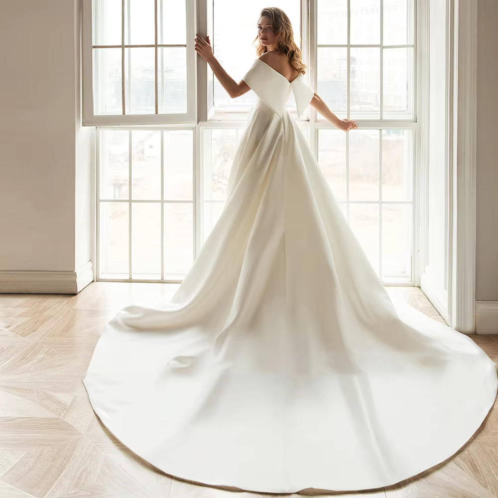 Stately pure white satin A-line bridal gown featuring a modern asymmetric draped off-the-shoulder neckline and a seamless floor-length silhouette.