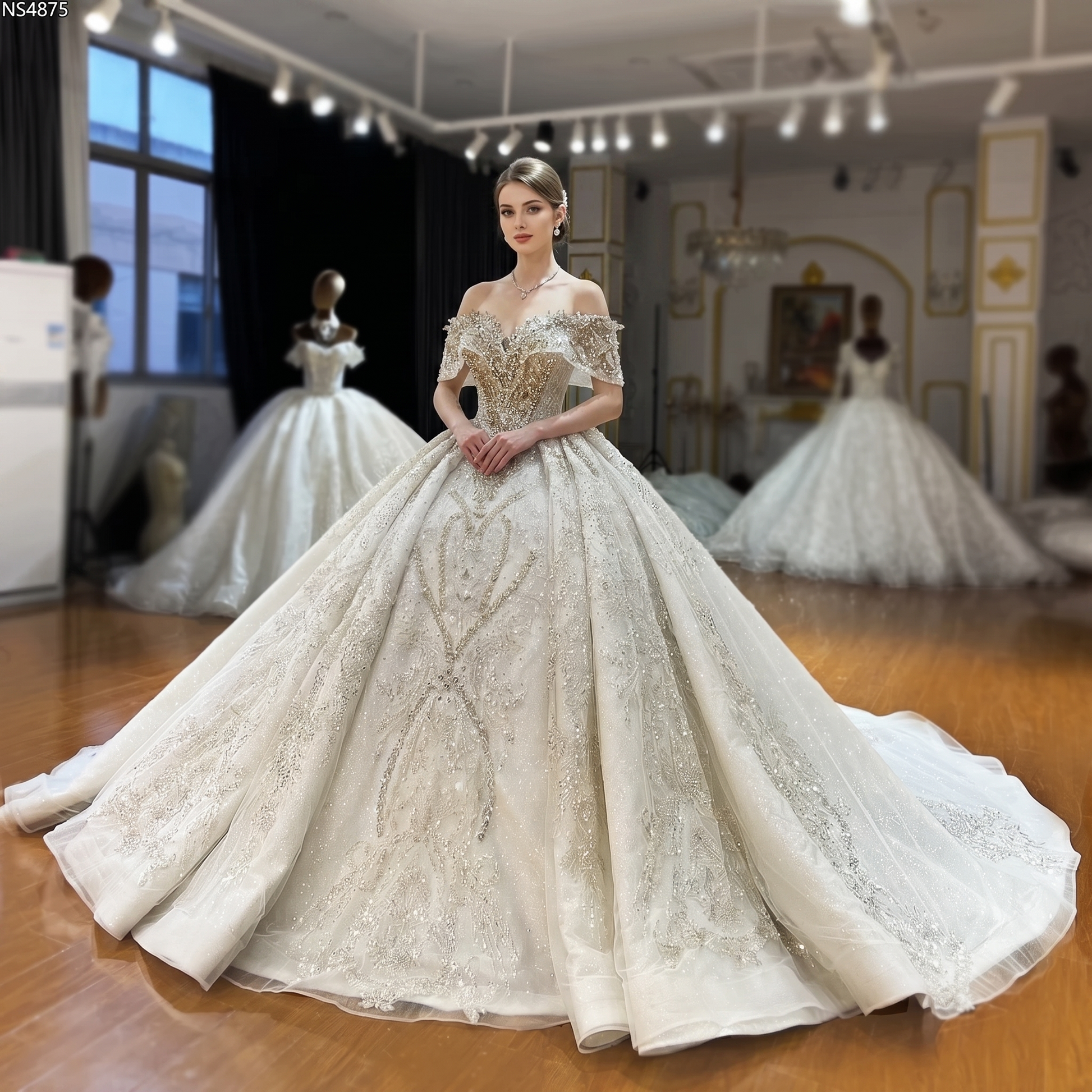 Full front view of a model in a bridal salon wearing the luxury off-the-shoulder beaded wedding gown with an elegant, sparkling ball gown silhouette.