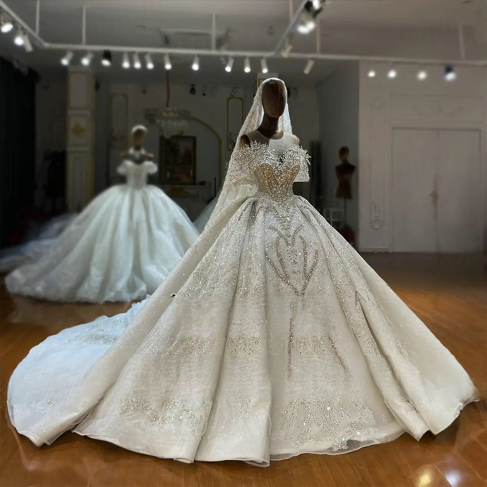 Full front view of an elegant off-the-shoulder beaded wedding gown on a mannequin, highlighting the grand flared skirt and exquisite bridal embellishments.