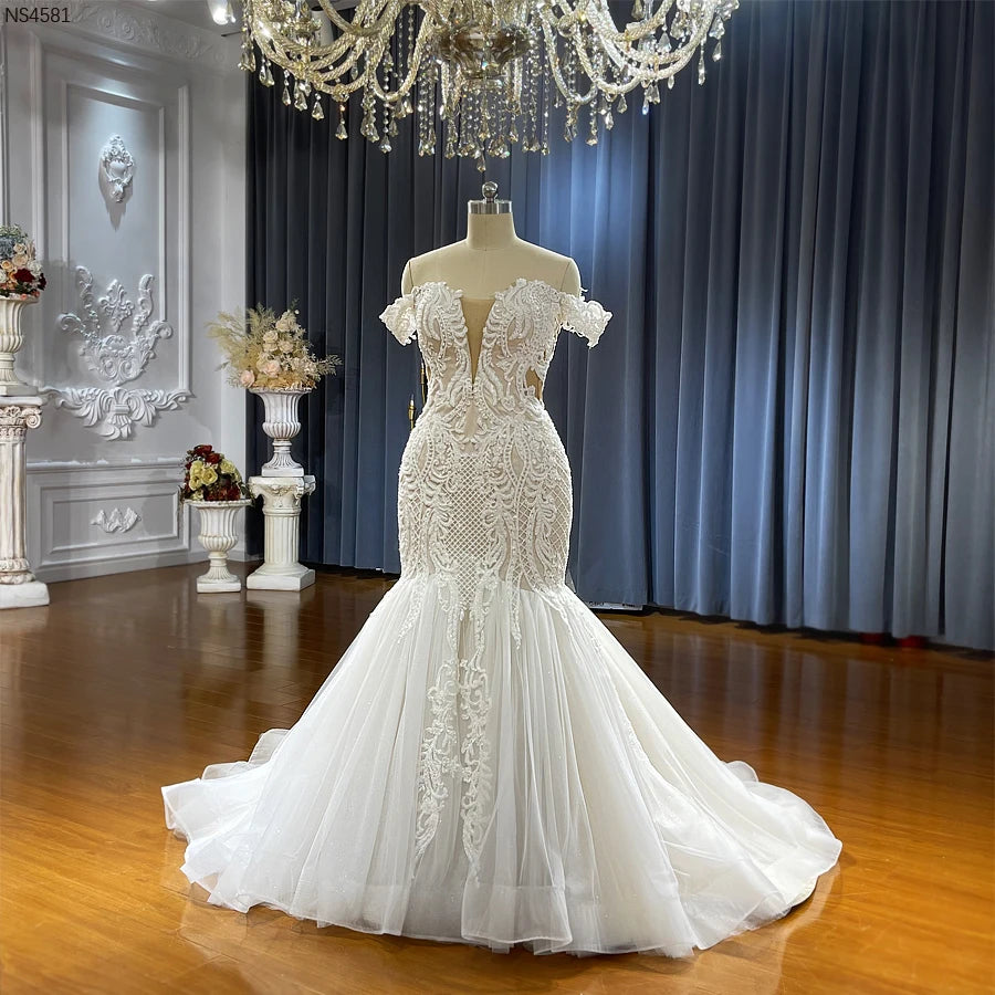 Front perspective of the lace mermaid wedding dress on a mannequin, highlighting the detailed floral embroidery and delicate off-the-shoulder sleeves.