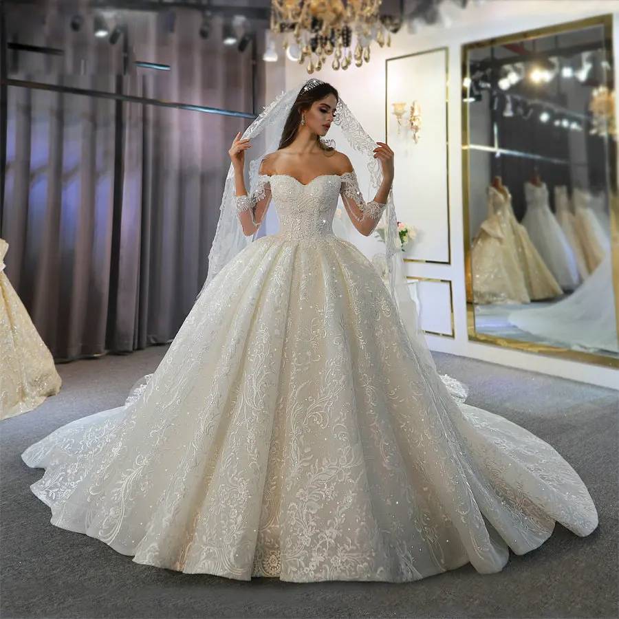 Front view of an off-the-shoulder long sleeve lace wedding dress featuring a sweetheart neckline and shimmering floral embroidery.