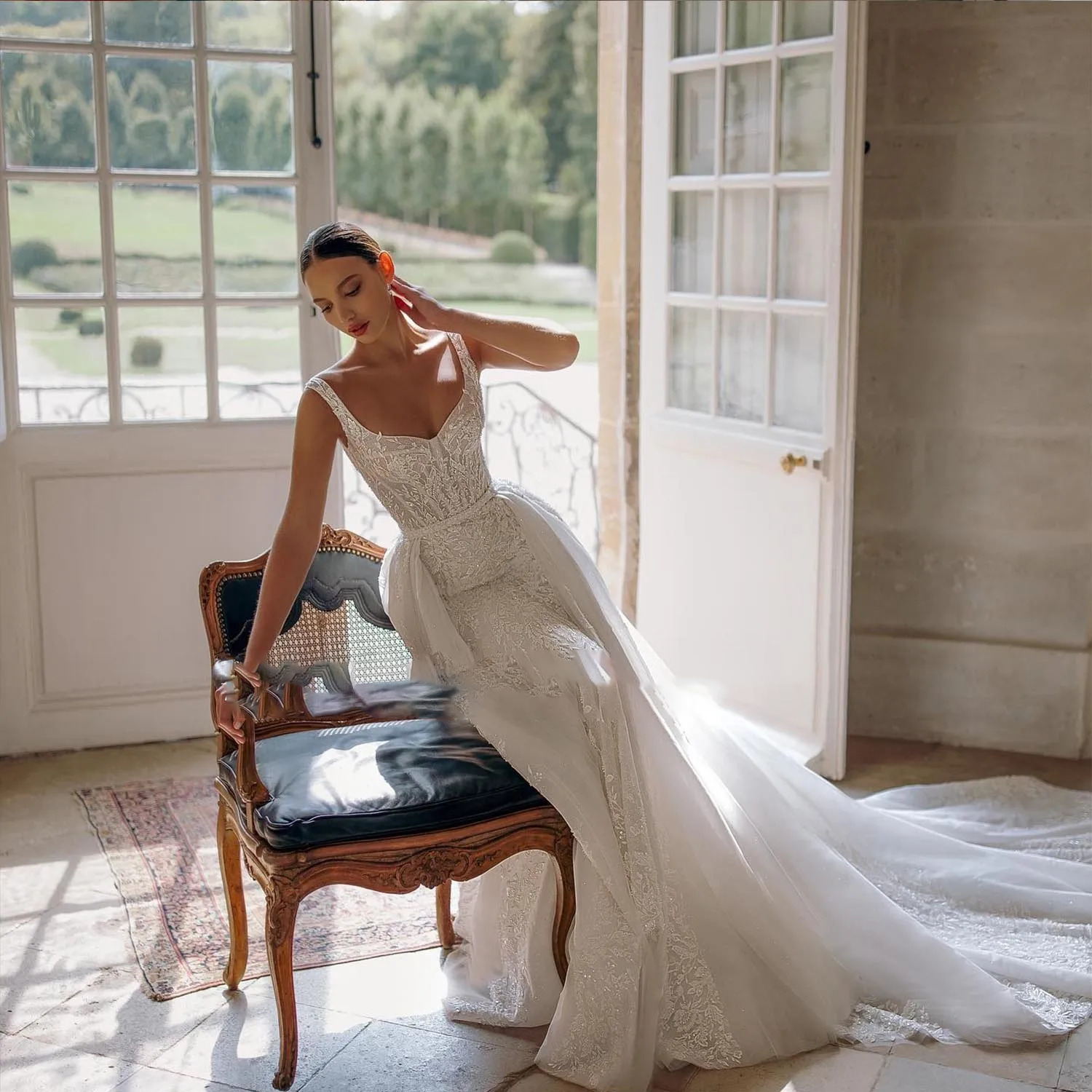 Elegant off-the-shoulder mermaid wedding dress styled with a dramatic sheer tulle detachable overskirt train for a 2-in-1 bridal look.