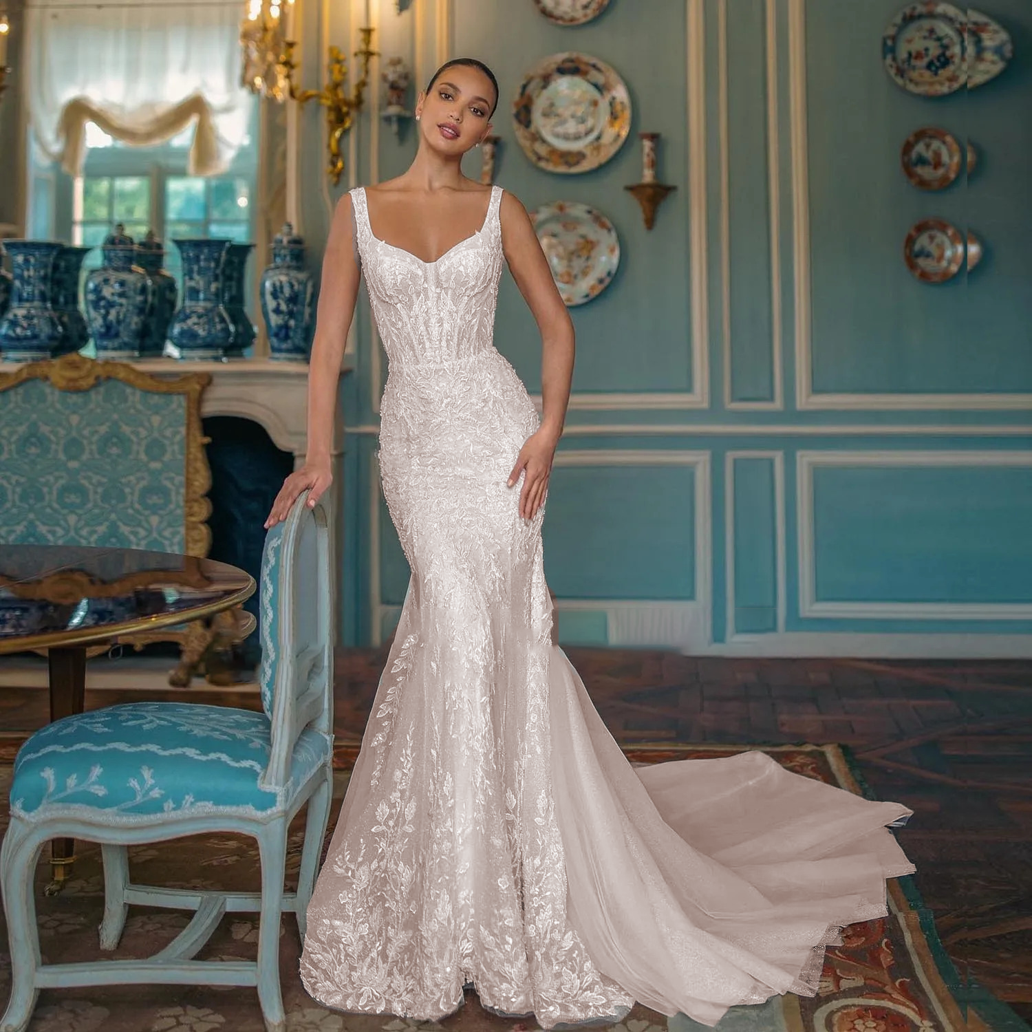 Glamorous sweetheart mermaid bridal gown with shimmering silver-threaded embroidery and a structured, corseted hourglass silhouette.