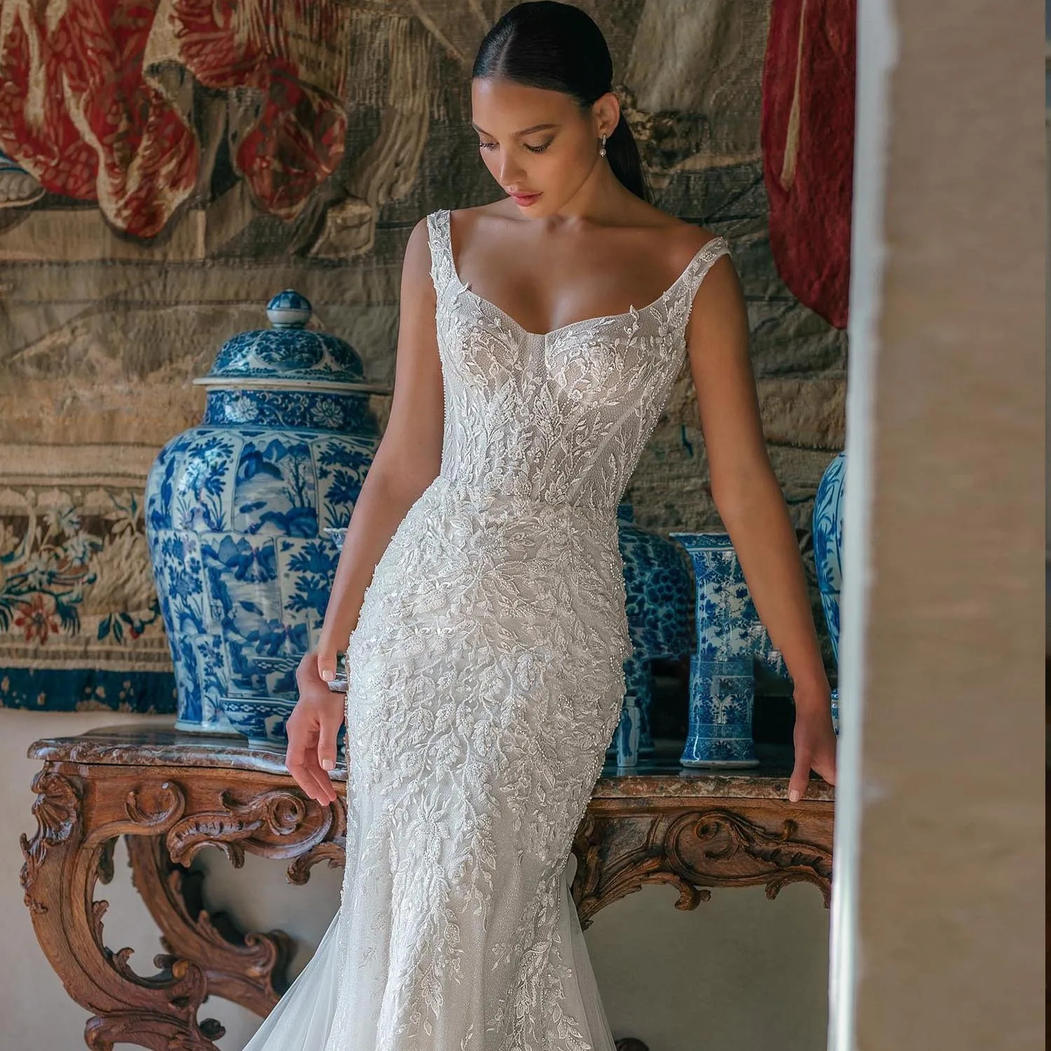 Macro view of a premium beaded lace wedding dress bodice highlighting intricate hand-stitched crystals and a structured bustier design.