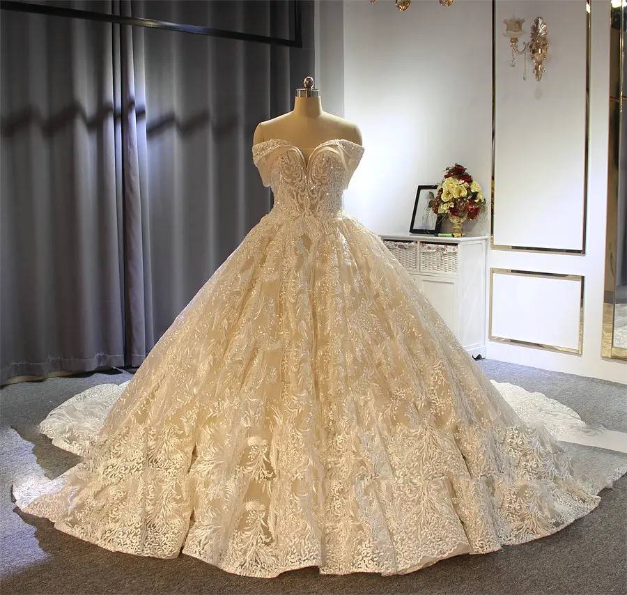 Full-length view of a luxury champagne-toned princess bridal dress featuring a sweetheart neckline and off-the-shoulder straps.