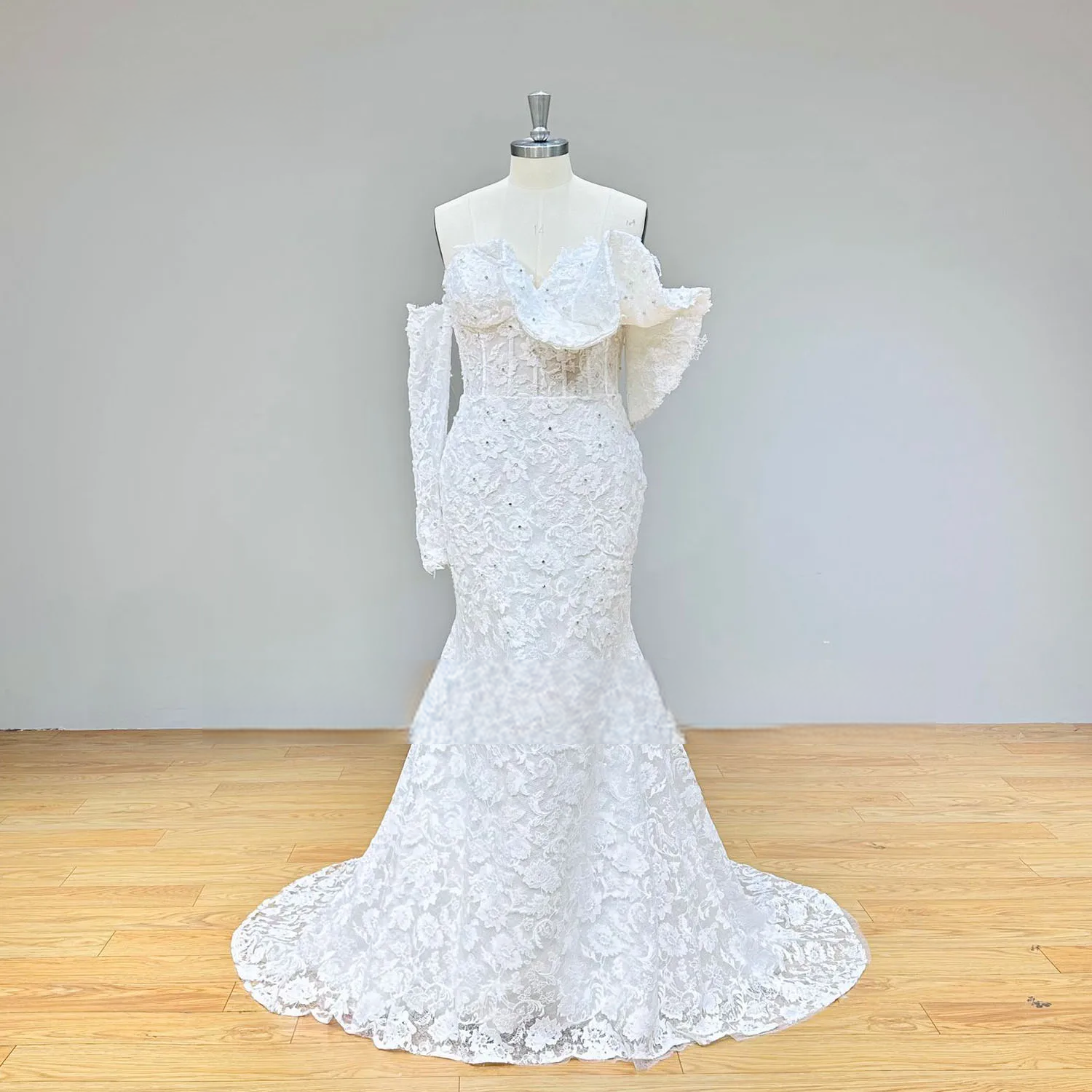 Front full-length view of the fitted all-over lace mermaid wedding dress silhouette, displaying the intricate floral patterns and the flared mermaid hemline.