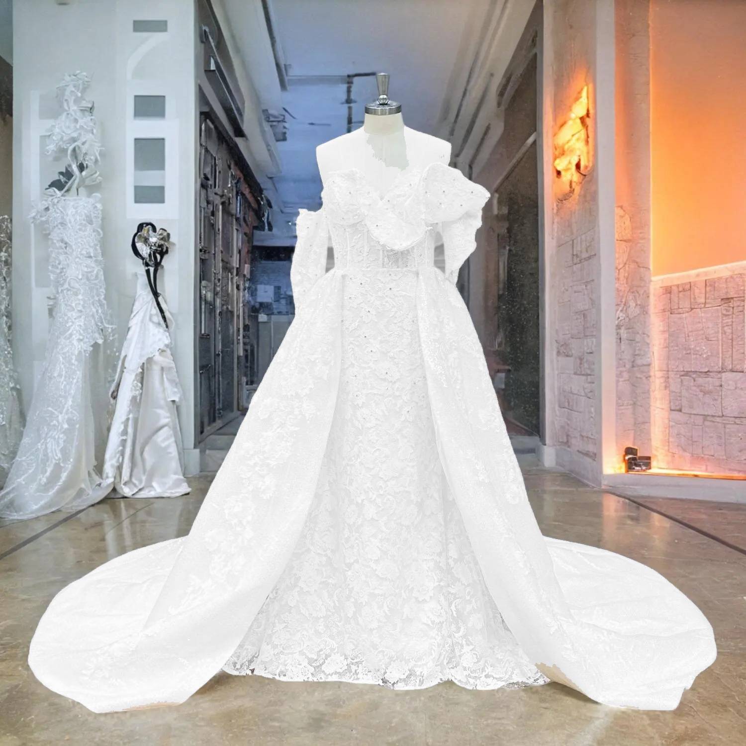 Full front display of a white off-shoulder mermaid wedding gown with a detachable lace overskirt, highlighting the versatile 2-in-1 bridal look under soft lighting.