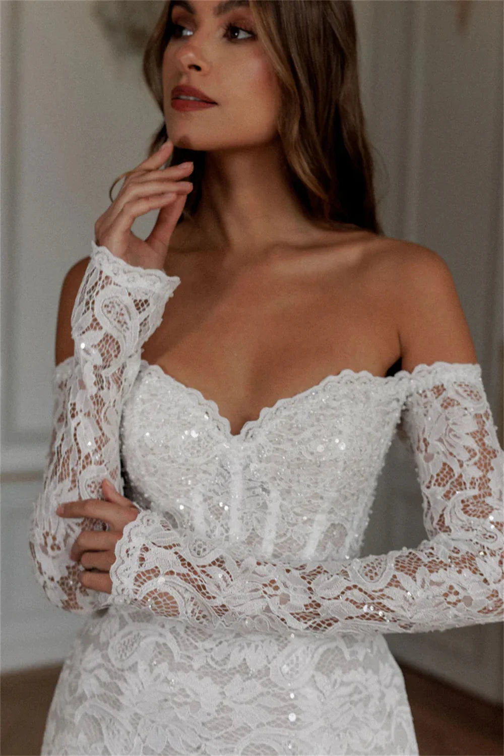 Detailed close-up of a modern lace bridal mini dress bodice highlighting the scalloped sweetheart neckline, structured corset boning, and sparkly floral lace appliques.