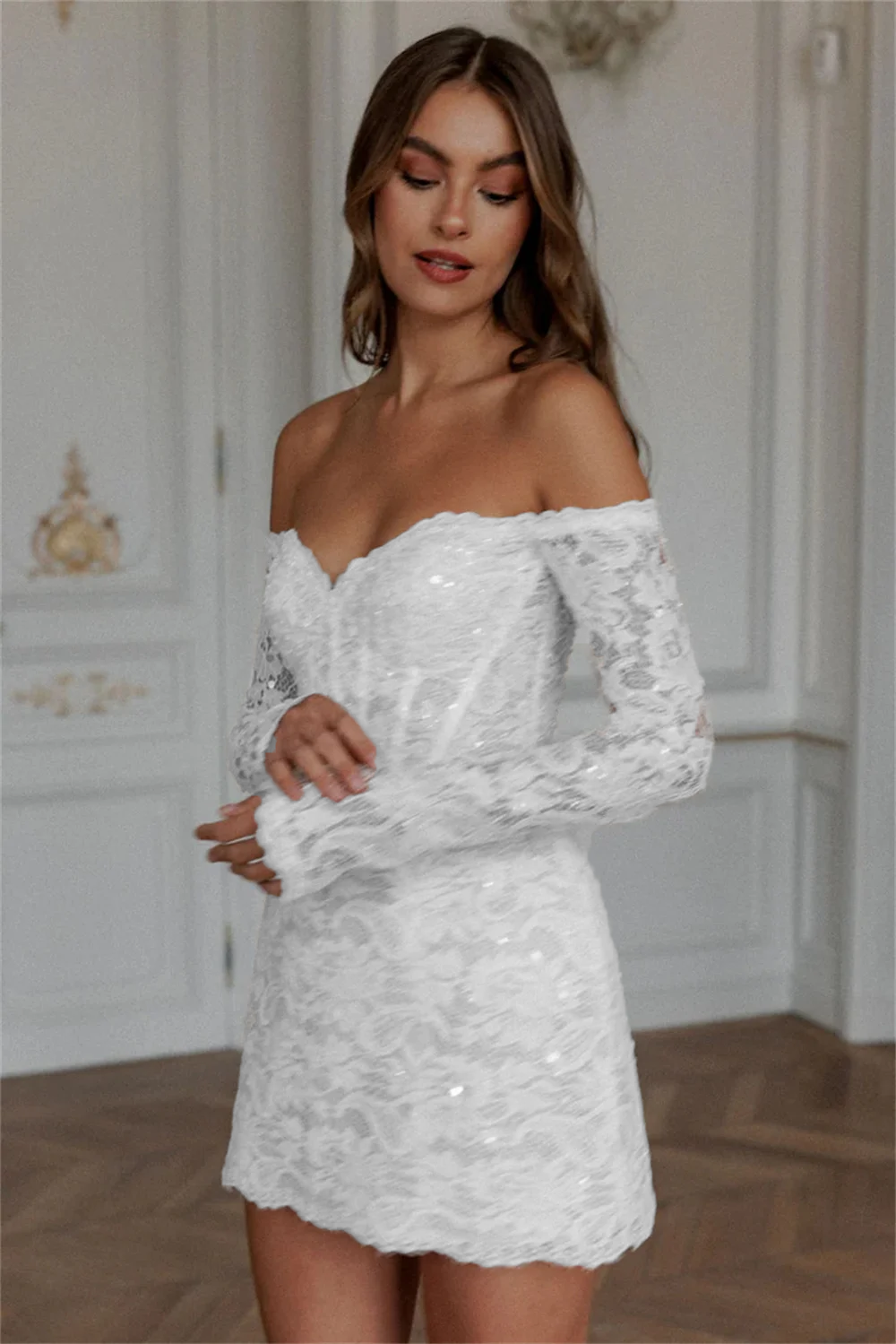 Chic pure white long sleeve short bridal dress with all-over embroidered floral lace details and a structured sweetheart corset top for an afterparty.