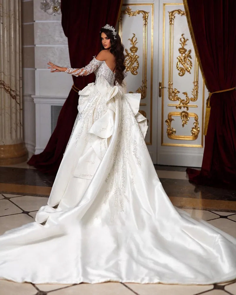 A studio mannequin displaying the full front silhouette of a luxury off-the-shoulder mermaid wedding dress with sparkling beadwork and sequin embellishments.
