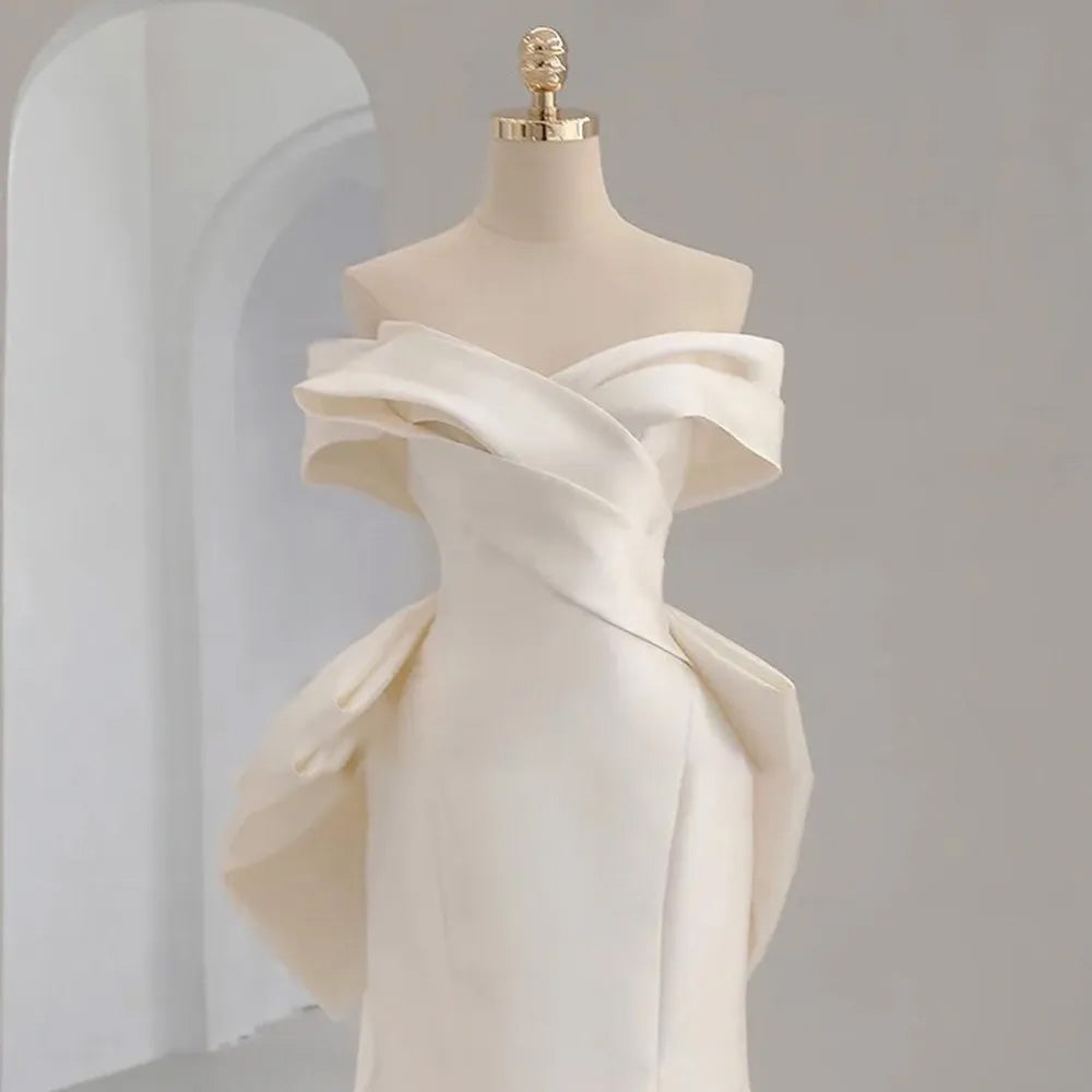 Side profile view of an off-the-shoulder mermaid wedding gown with short sleeves and a sweetheart neck, displayed on a mannequin.