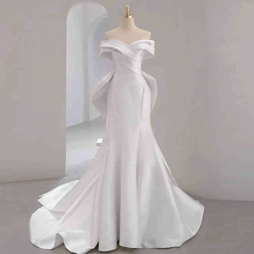 A full-length mannequin display of a white mermaid wedding dress, showcasing the balance of the off-the-shoulder cut and sweetheart neckline.
