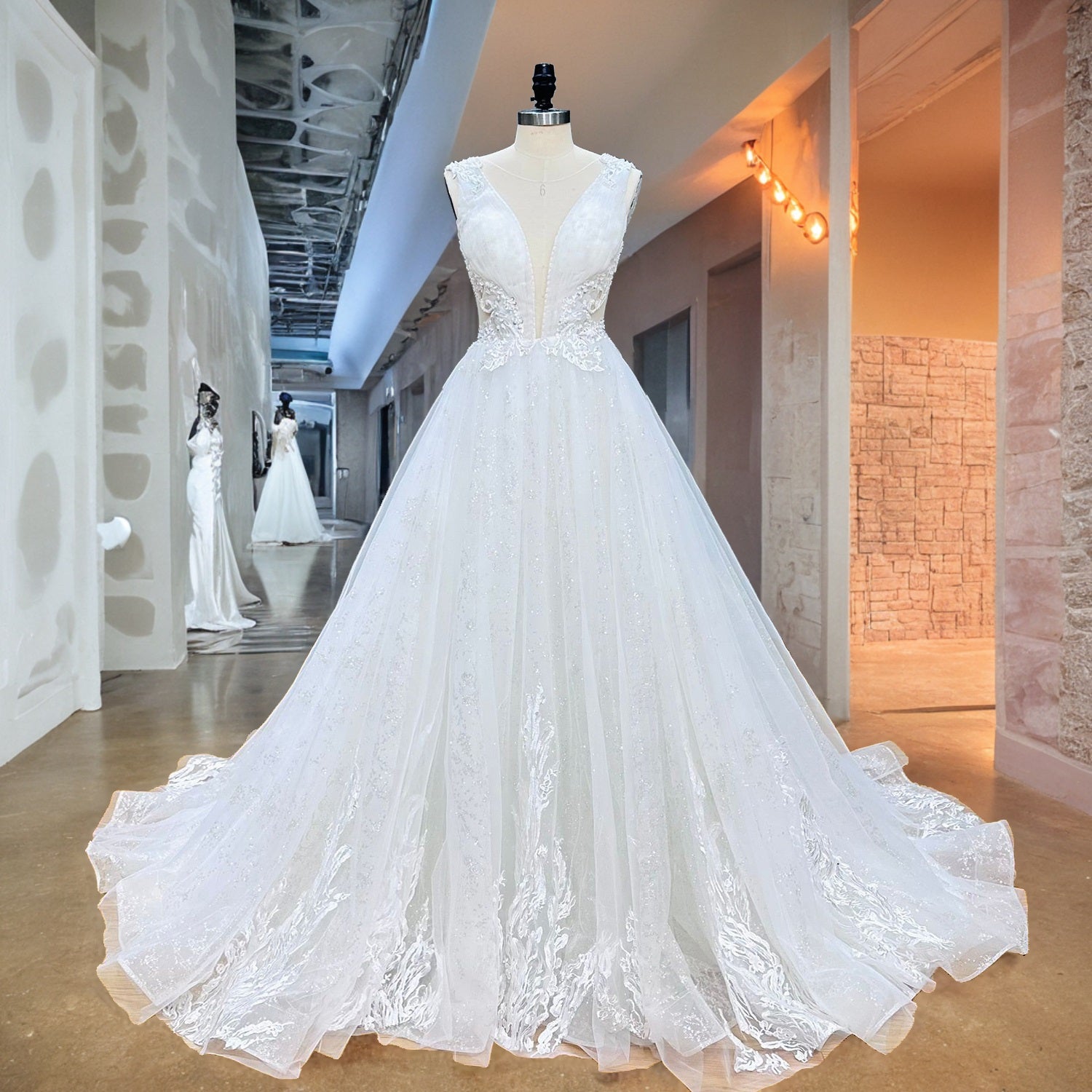 Studio product photography showing the full front view of an A-line wedding dress with a beaded floral lace bodice and glittering tulle skirt.