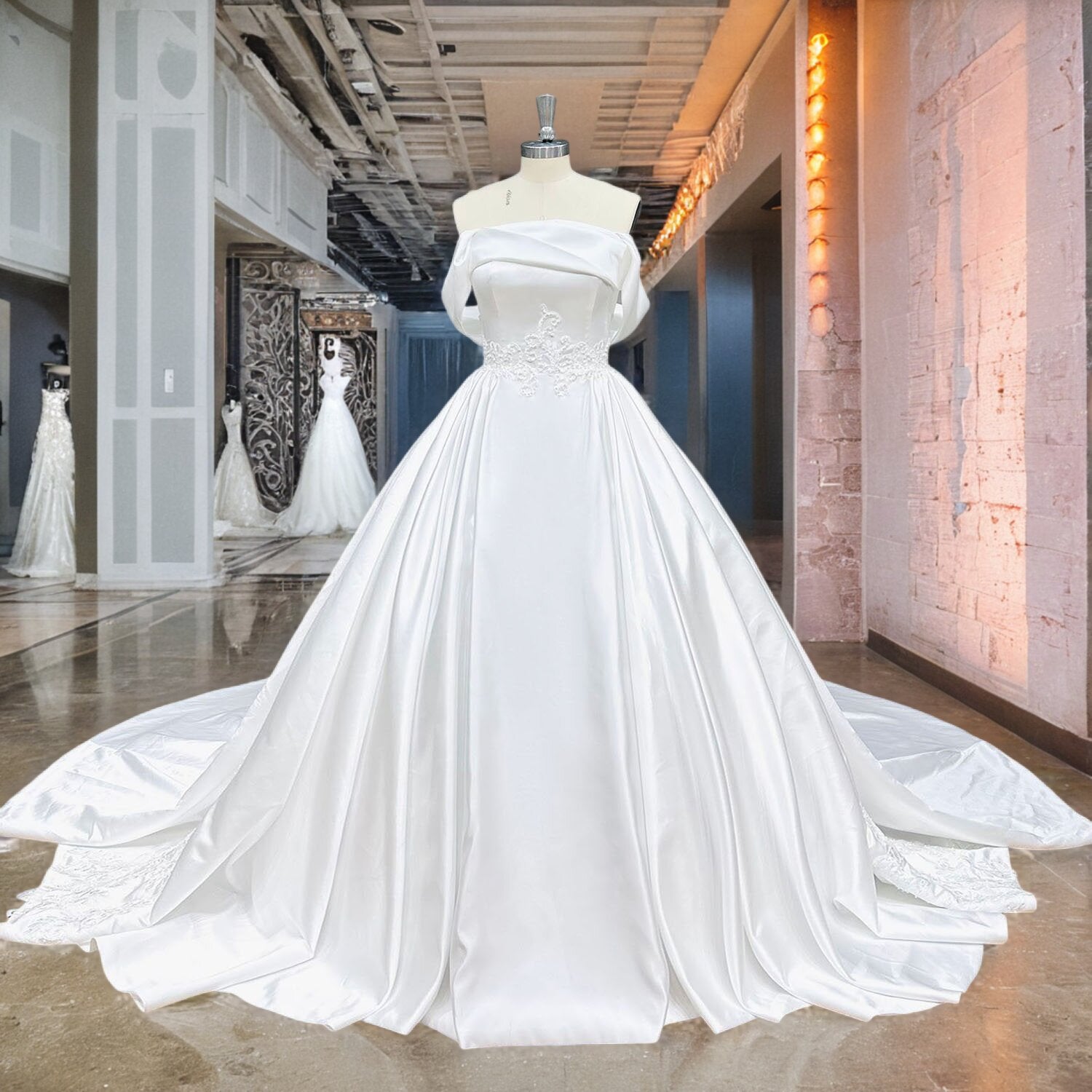 Luxury white satin off-the-shoulder bridal gown with fine pearl appliques and a pleated cathedral-length train displayed on a mannequin.