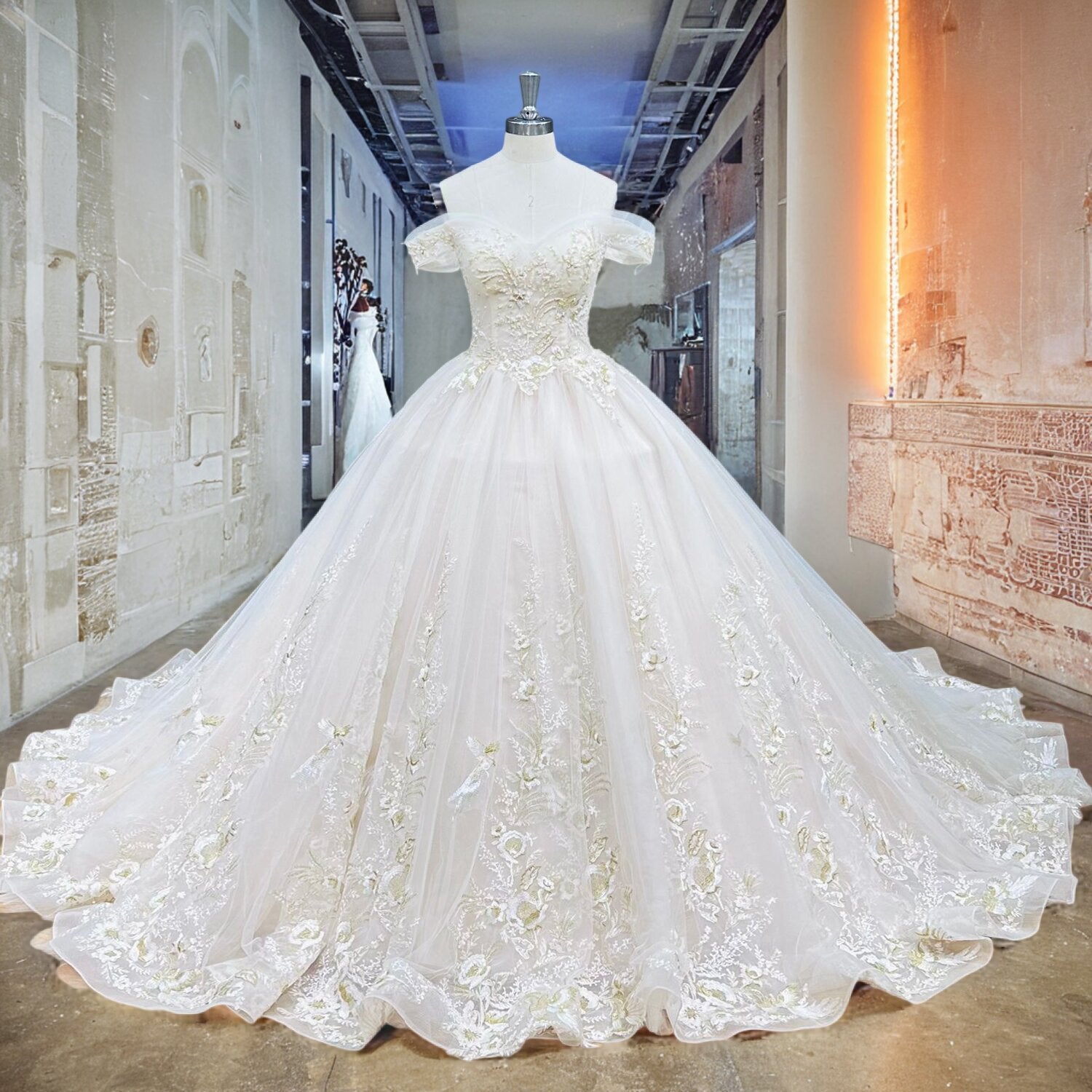Full front view of a luxury champagne tulle ball gown wedding dress with gold embroidered appliques on a showroom mannequin.