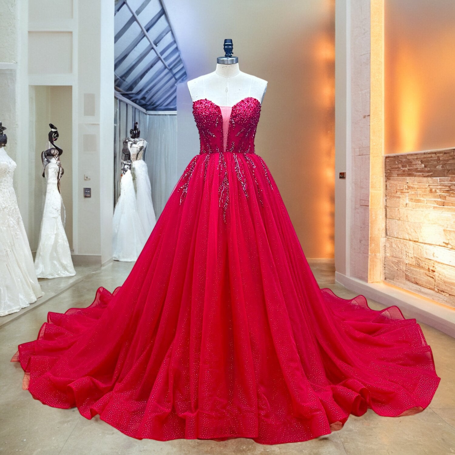Full front view of a luxury red wedding ball gown on a mannequin, highlighting the sheer plunge illusion mesh on the bodice and cascading crystal beadwork radiating down the waist.