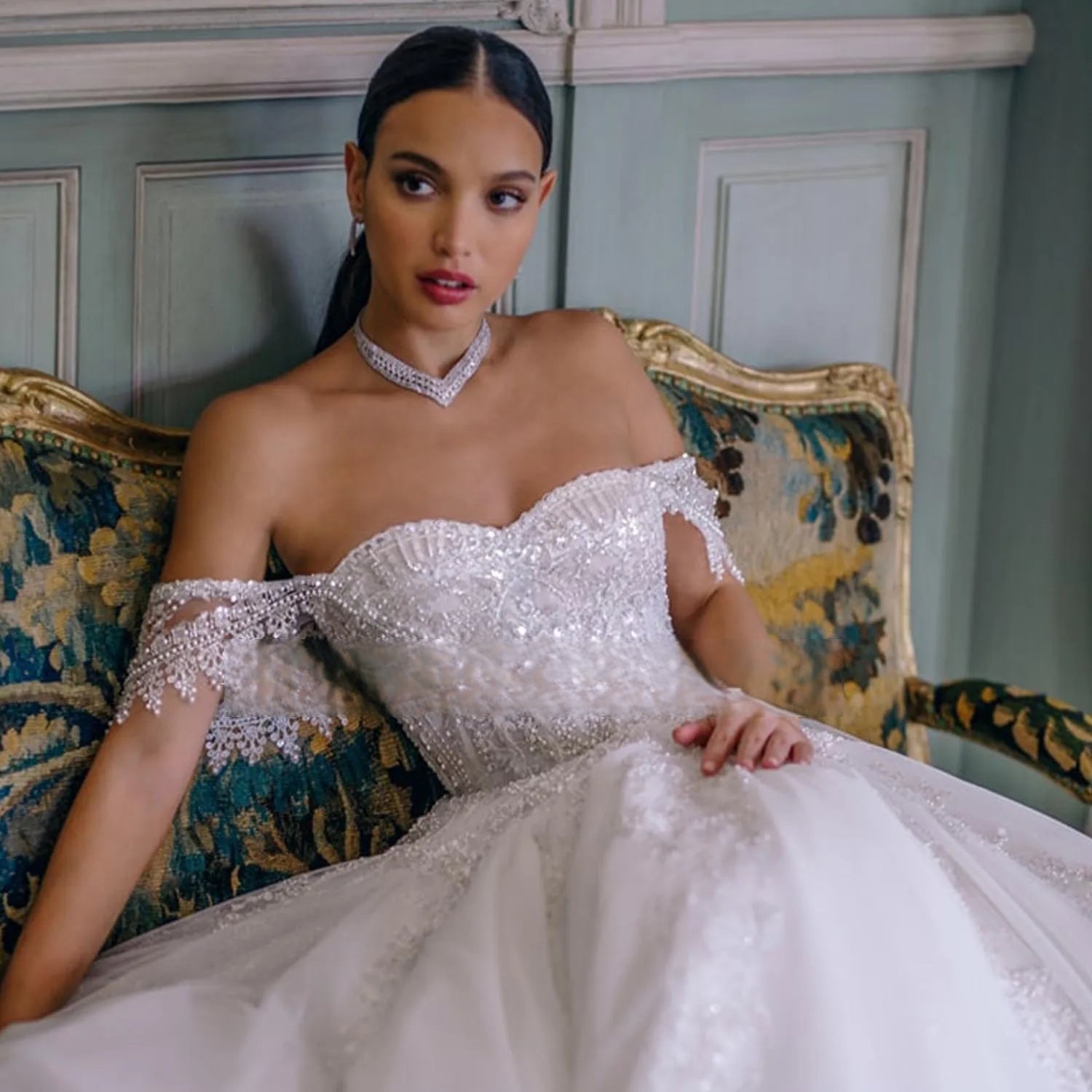Close-up of a heavily embellished sweetheart neckline bridal bodice with geometric crystal beading and metallic silver thread appliques.