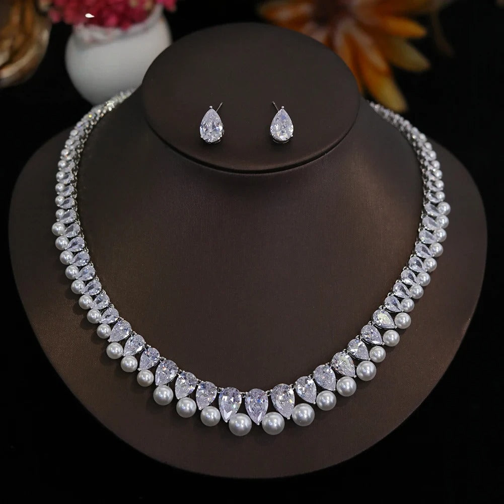 Front profile view of a cubic zirconia pearl wedding choker necklace and teardrop earring set displayed on a dark jewelry bust.