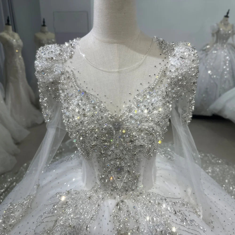 Close-up view of a wedding dress back closure, focusing on an elegant ribbon lace-up corset framed by delicate pearl trims and sheer floral lace appliques.