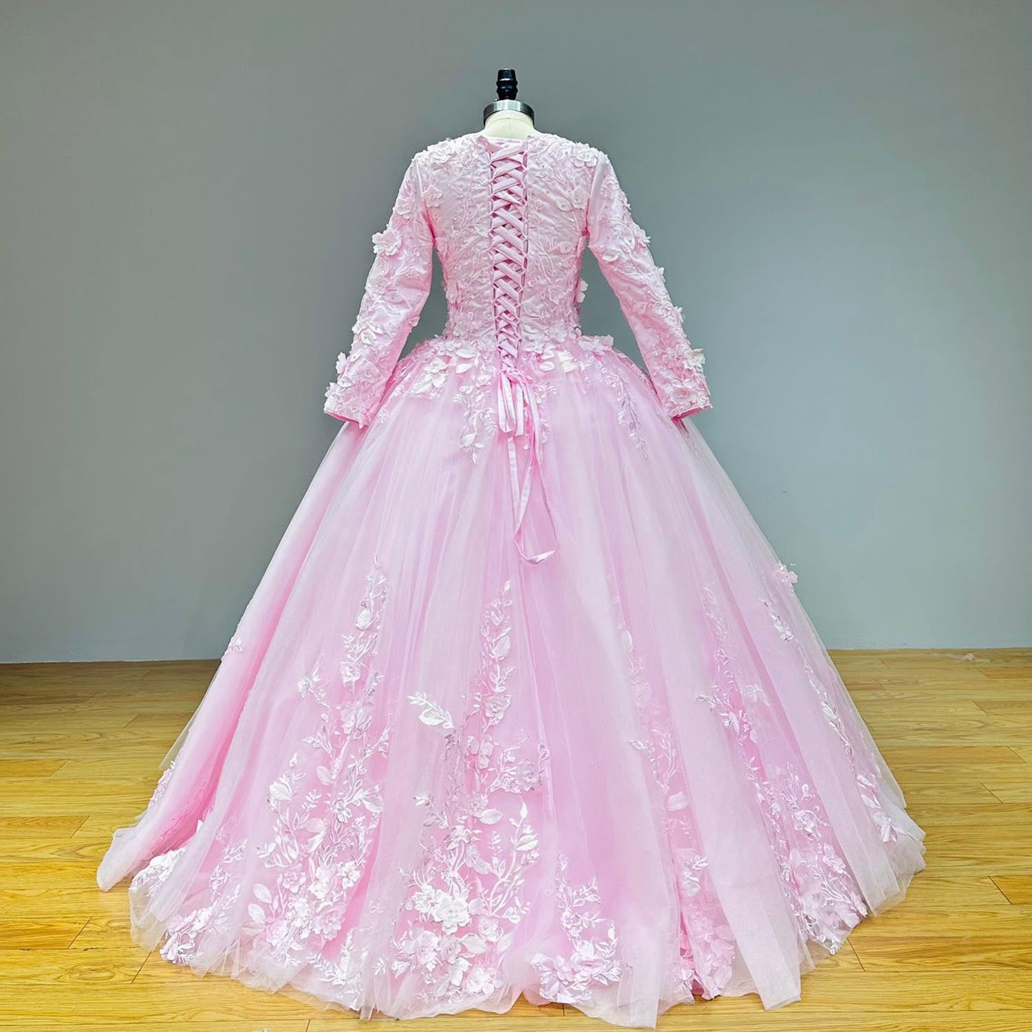 Full back view of a pink princess wedding dress on a dress form without the overskirt, showing the structured corset back and elegant lace train cascading to the floor.