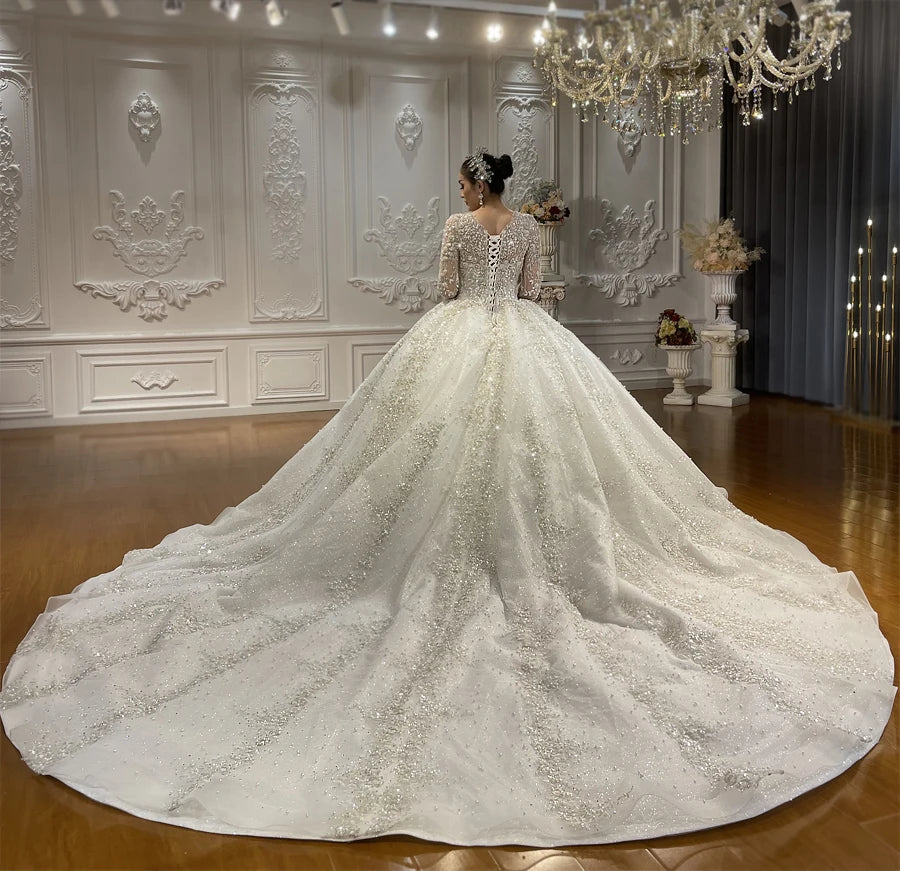 Rear perspective of the plus size wedding gown highlighting a sophisticated lace-up corset back and the magnificent sweep of an encrusted, shimmering cathedral-length train.