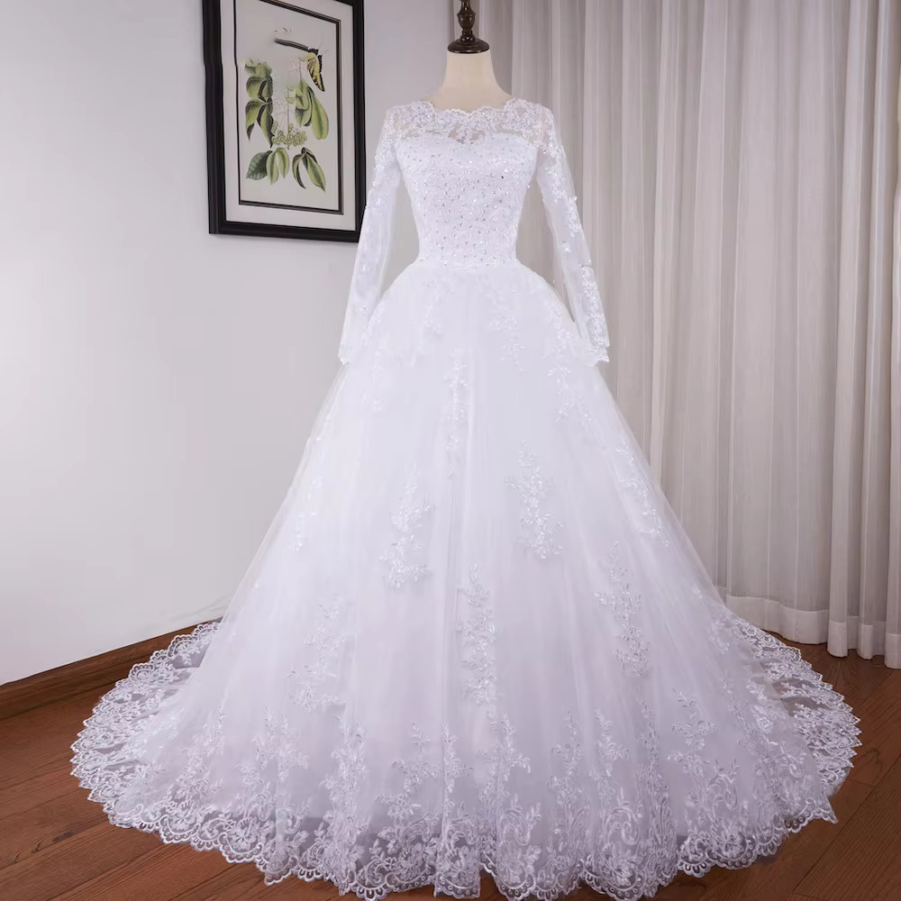 High-resolution portrait of the regal lace ball gown bridal dress, showcased in a sophisticated warm champagne or light gold tint variant under studio lighting.