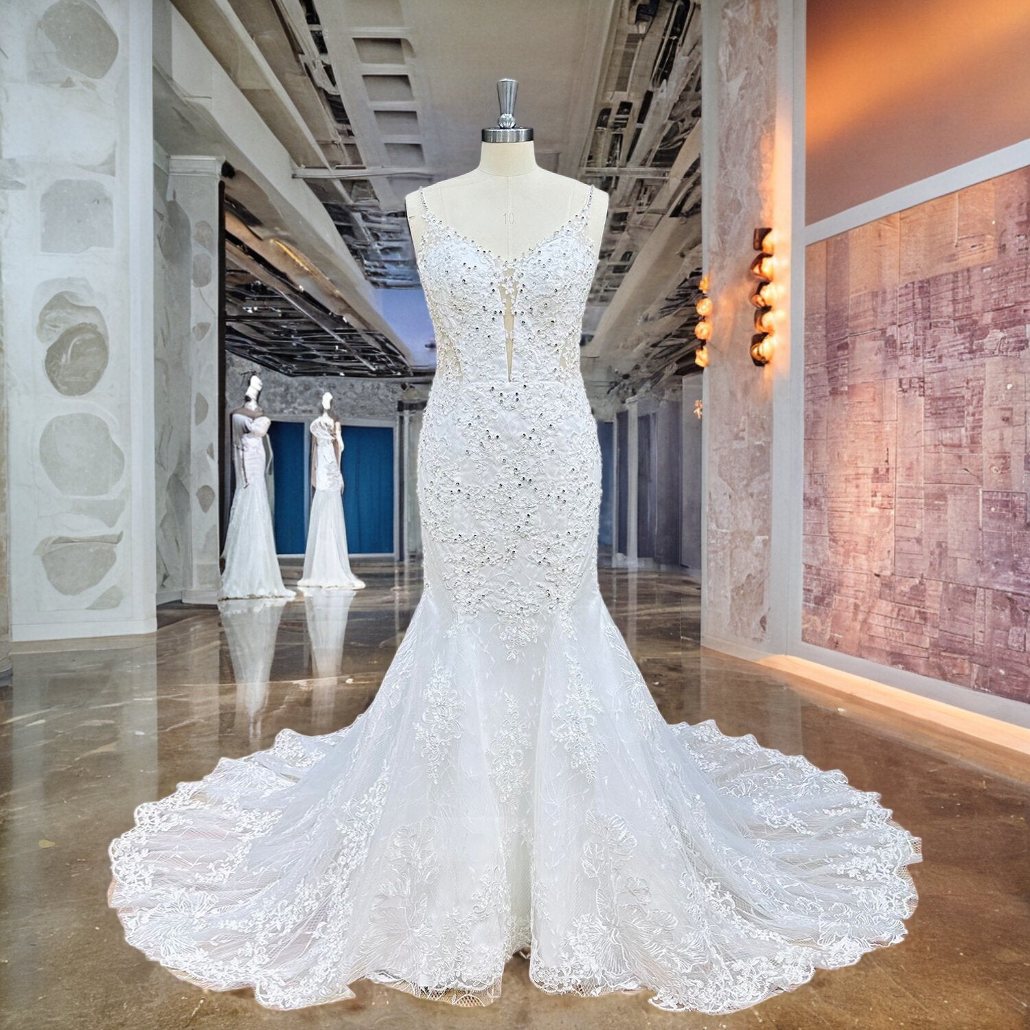 Luxury white lace mermaid bridal dress featuring a deep illusion plunge bodice and shimmering crystal embellishments displayed on a mannequin.