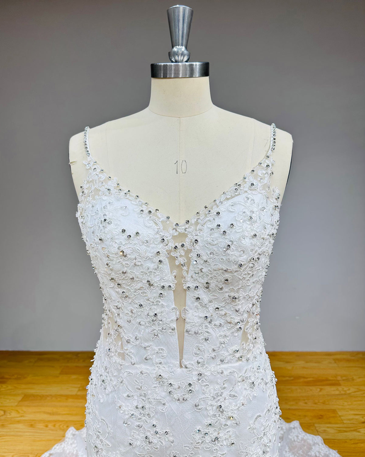 Detailed view of a plunging sweetheart bodice decorated with a mix of silver rhinestones, micro-crystals, and premium floral lace embroidery.