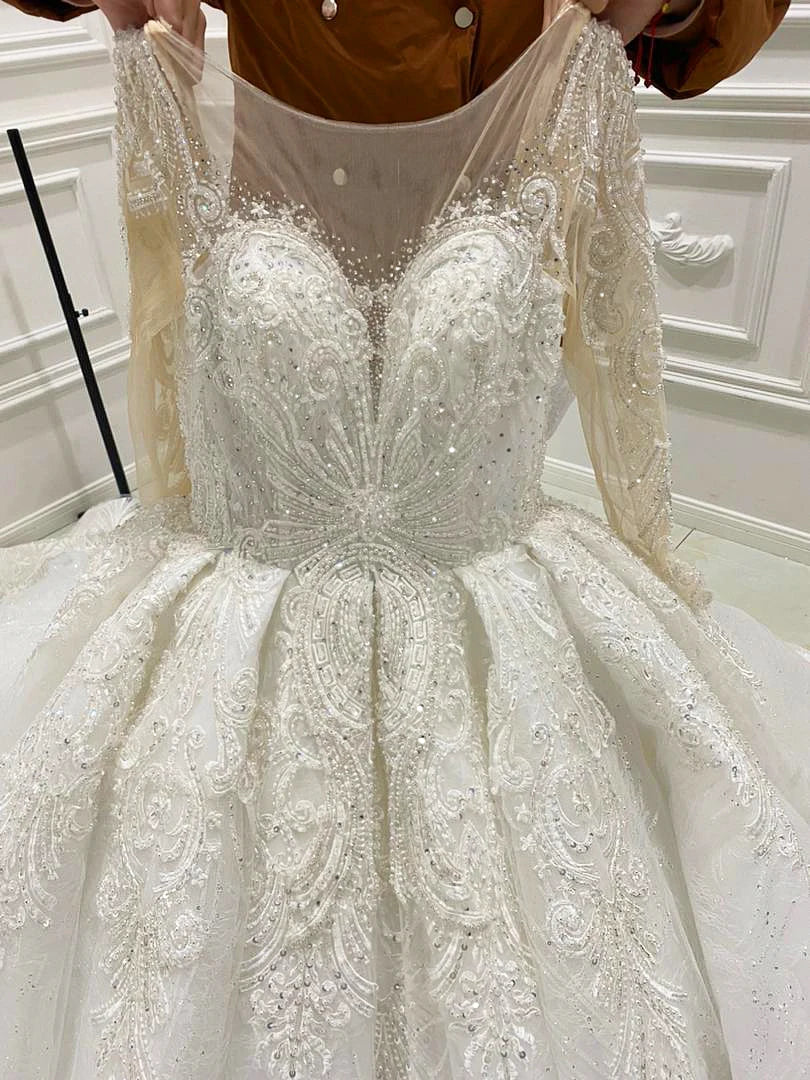 Detailed close-up of the exquisite heavily beaded bodice on an elegant bridal ball gown, highlighting the sheer illusion neckline and sparkling crystal embroidery.