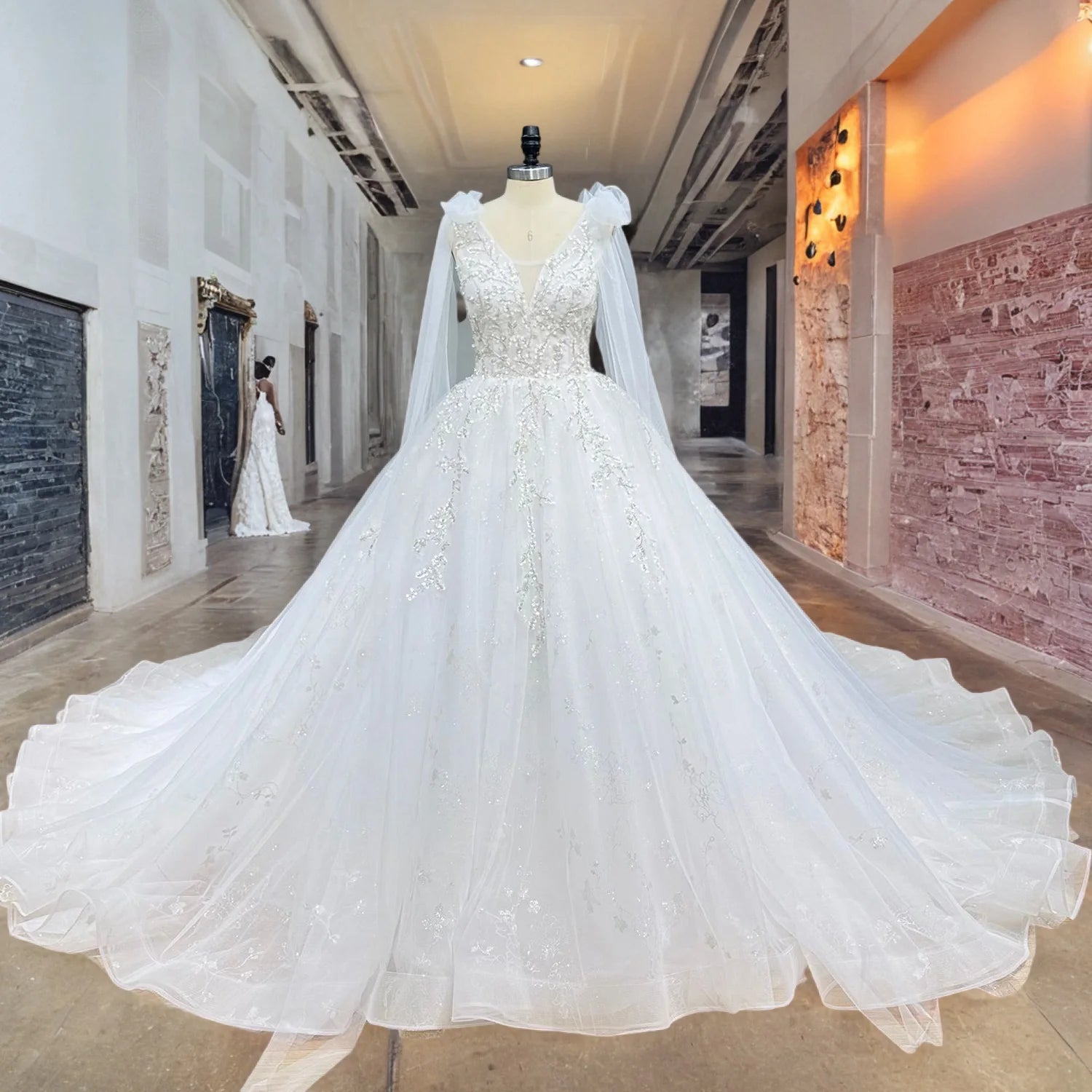 Full front view of a luxury princess wedding dress on a mannequin featuring intricate silver floral beadwork, a deep V-neck, and a voluminous layered tulle chapel train.