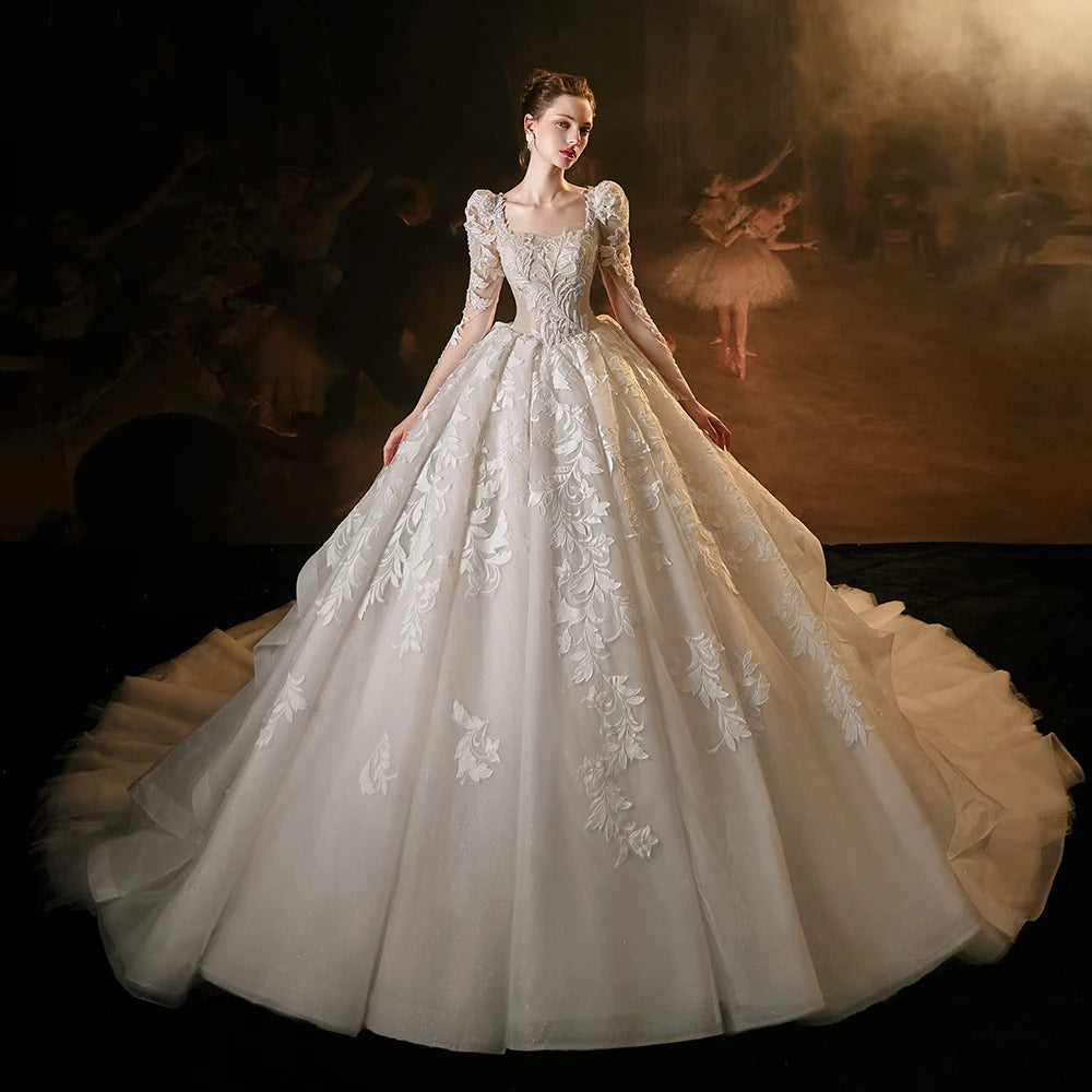 Full front view of a princess ball gown wedding dress with an elegant square collar and full sleeves, featuring heavy silver crystal beading and a grand, shimmering voluminous skirt.