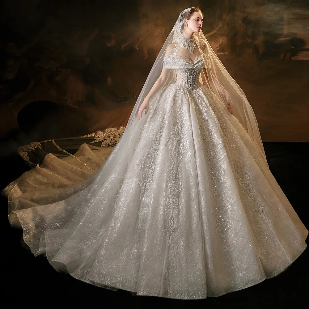 Full-length side view of a sparkling glitter tulle ball gown wedding dress featuring elegant draped short sleeves, detailed silver embroidery, and a sheer bridal veil.
