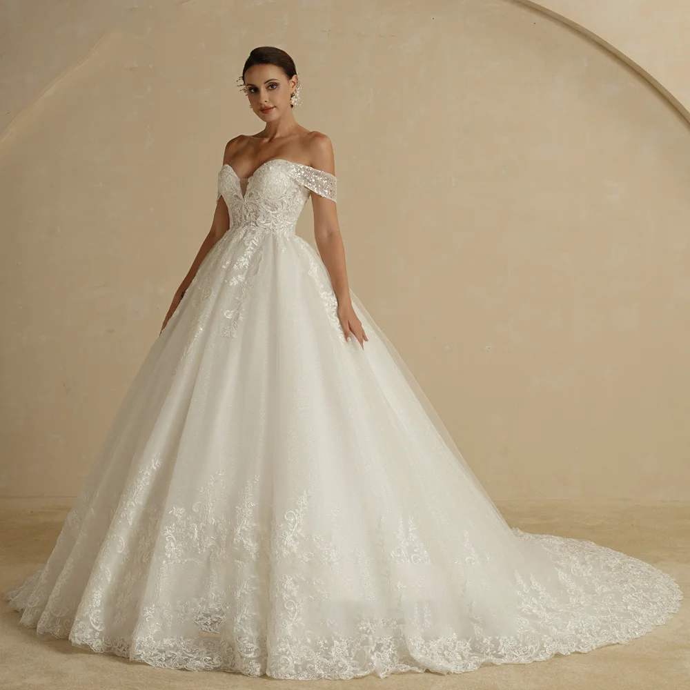 A princess-style bridal gown with an off-shoulder neckline, showcasing a glitter skirt and intricate lace applique work, displayed on a model.