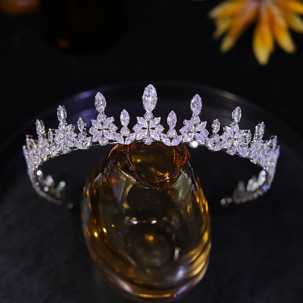 Front view of an elegant bridal crystal tiara crown resting beautifully on a glass display stand