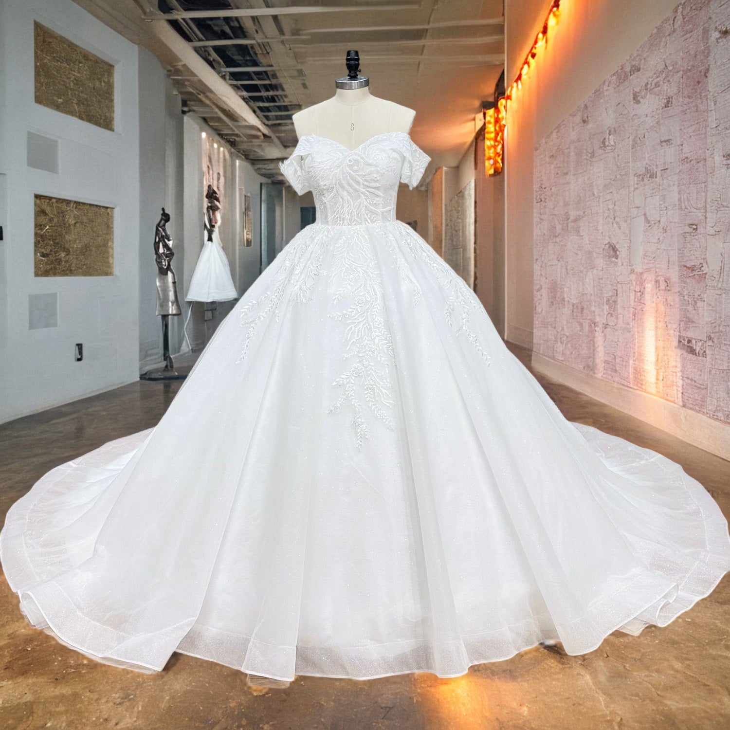 Luxury white off-the-shoulder princess ball gown wedding dress with intricate vine lace appliques displayed on a mannequin in a bridal boutique corridor.