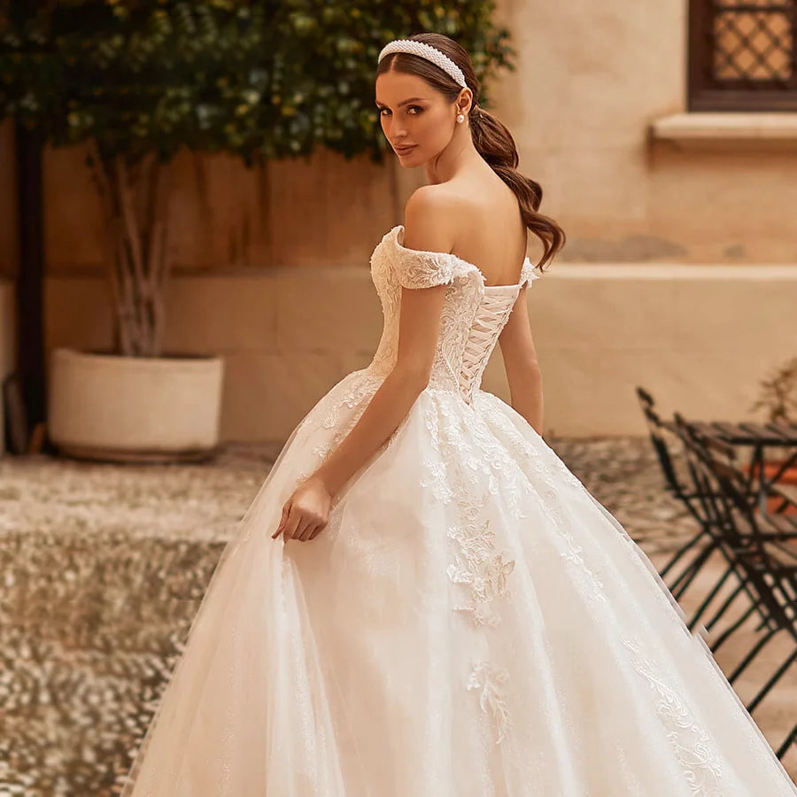 A back view of a princess wedding dress showcasing a corset-style lace-up closure and an embroidered bodice.