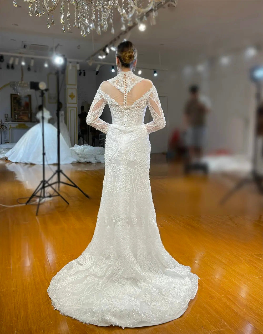Elegant back view of the fitted lace mermaid wedding dress silhouette, showcasing a sheer illusion keyhole back, corset lace-up closure, and an intricate lace train without the removable skirt.