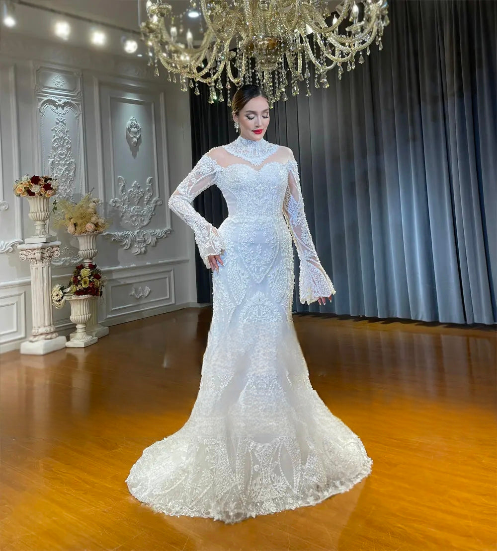 Front perspective of the fitted lace mermaid wedding dress silhouette, featuring a high illusion neckline, elegant hand-beaded lace appliques, and unique bell-cuff long sleeves.